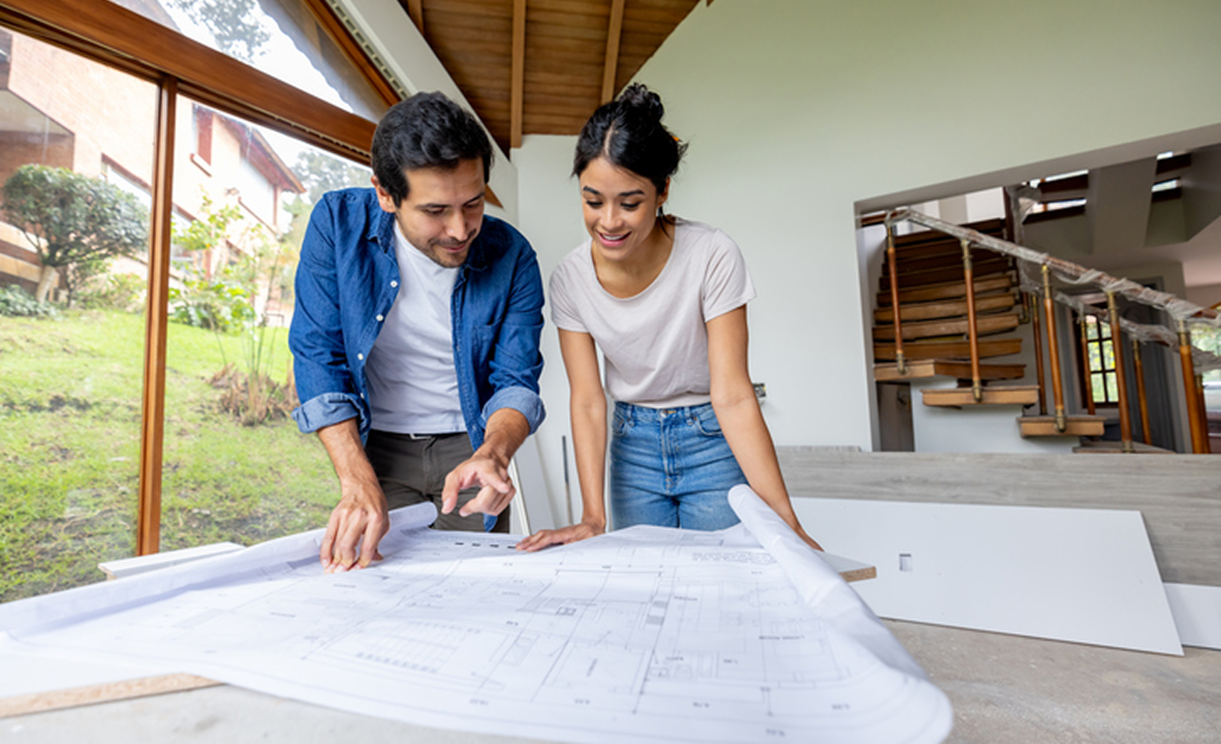 Two people examining house design plans